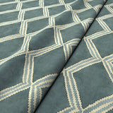Close-up of blue printed velvet fabric featuring an irregular diamond motif with a soft, luxurious pile. 