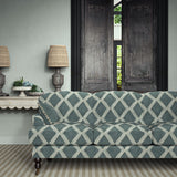 Sofa upholstered in blue printed velvet featuring an irregular diamond motif, styled in a timeless living room.