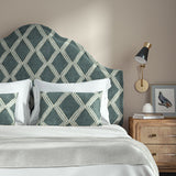 Bedroom with a curved upholstered headboard covered in blue printed velvet featuring an irregular diamond motif.