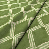 Close-up of green printed velvet fabric featuring an irregular diamond motif with a soft, luxurious pile. 
