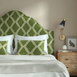 Bedroom with a curved upholstered headboard covered in green printed velvet featuring an irregular diamond motif.