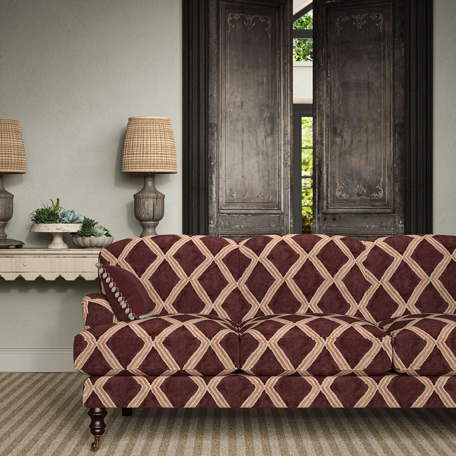 Sofa upholstered in maroon and pink printed velvet featuring an irregular diamond motif, styled in a timeless living room.
