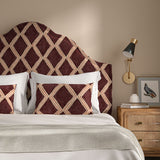 Bedroom with a curved upholstered headboard covered in maroon and pink printed velvet featuring an irregular diamond motif.