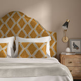 Bedroom with a curved upholstered headboard covered in brown and blue printed velvet featuring an irregular diamond motif.