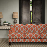 Sofa upholstered in orange and blue printed velvet featuring an irregular diamond motif, styled in a timeless living room.