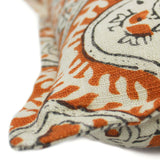 A orange, cream and black linen cushion with a central motif pattern.
