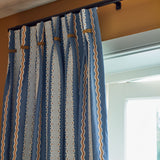 Embroidery curtain with blue, beige, and white stripes on a blue background.