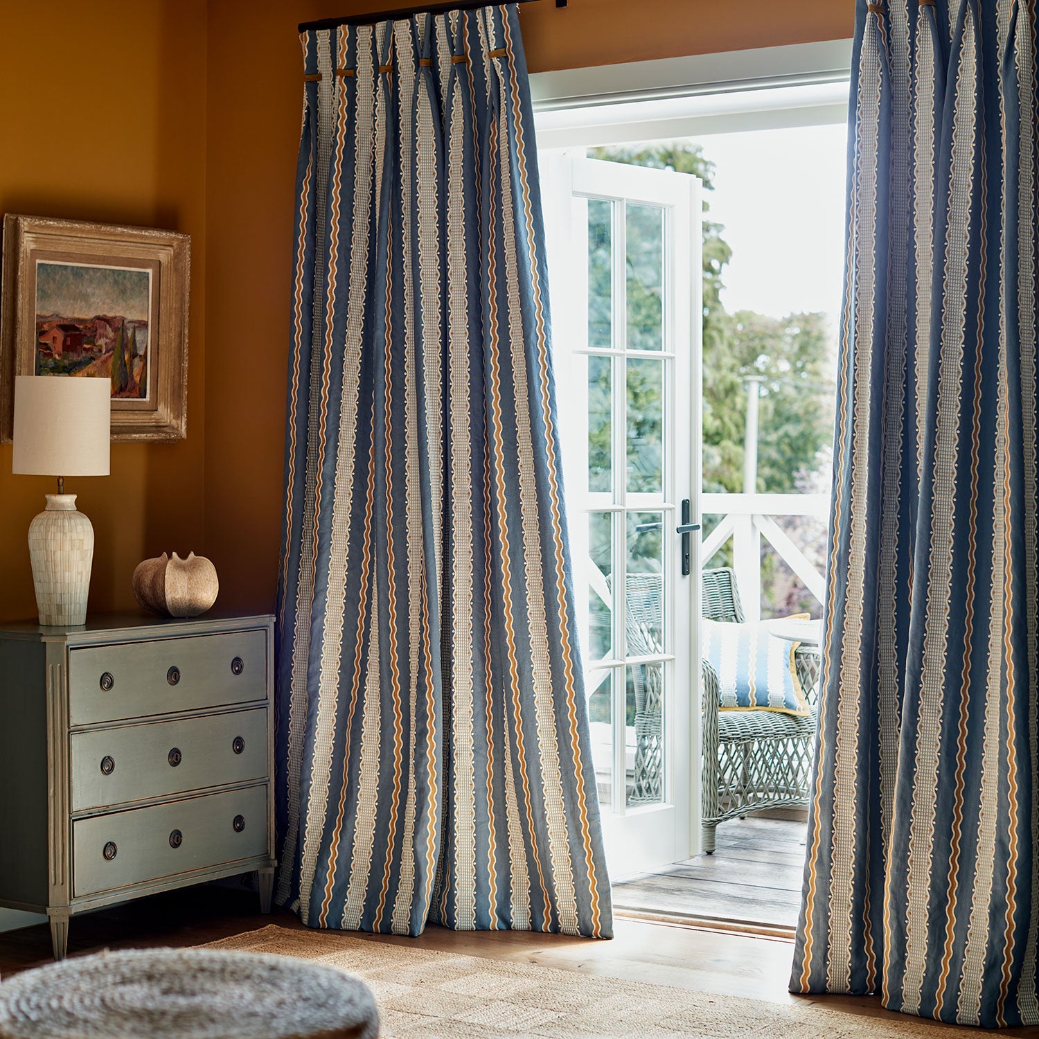 Embroidery curtain fabric with blue, beige, and white stripes on a blue background.