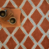 Styled close-up of red and blue printed velvet fabric featuring an irregular diamond motif with a soft, luxurious pile. 