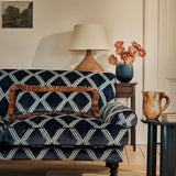 Sofa upholstered in blue printed velvet featuring an irregular diamond motif, styled in a timeless living room.