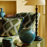 Detail of accent chair upholstered in green and blue printed velvet with an irregular diamond pattern, showcasing the fabric’s rich texture. 