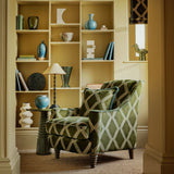 Accent chair upholstered in green and blue printed velvet with an irregular diamond pattern, showcasing the fabric’s rich texture. 