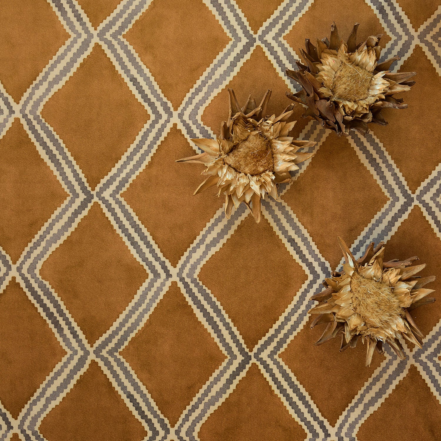 Styled close-up of brown and blue printed velvet fabric featuring an irregular diamond motif with a soft, luxurious pile. 