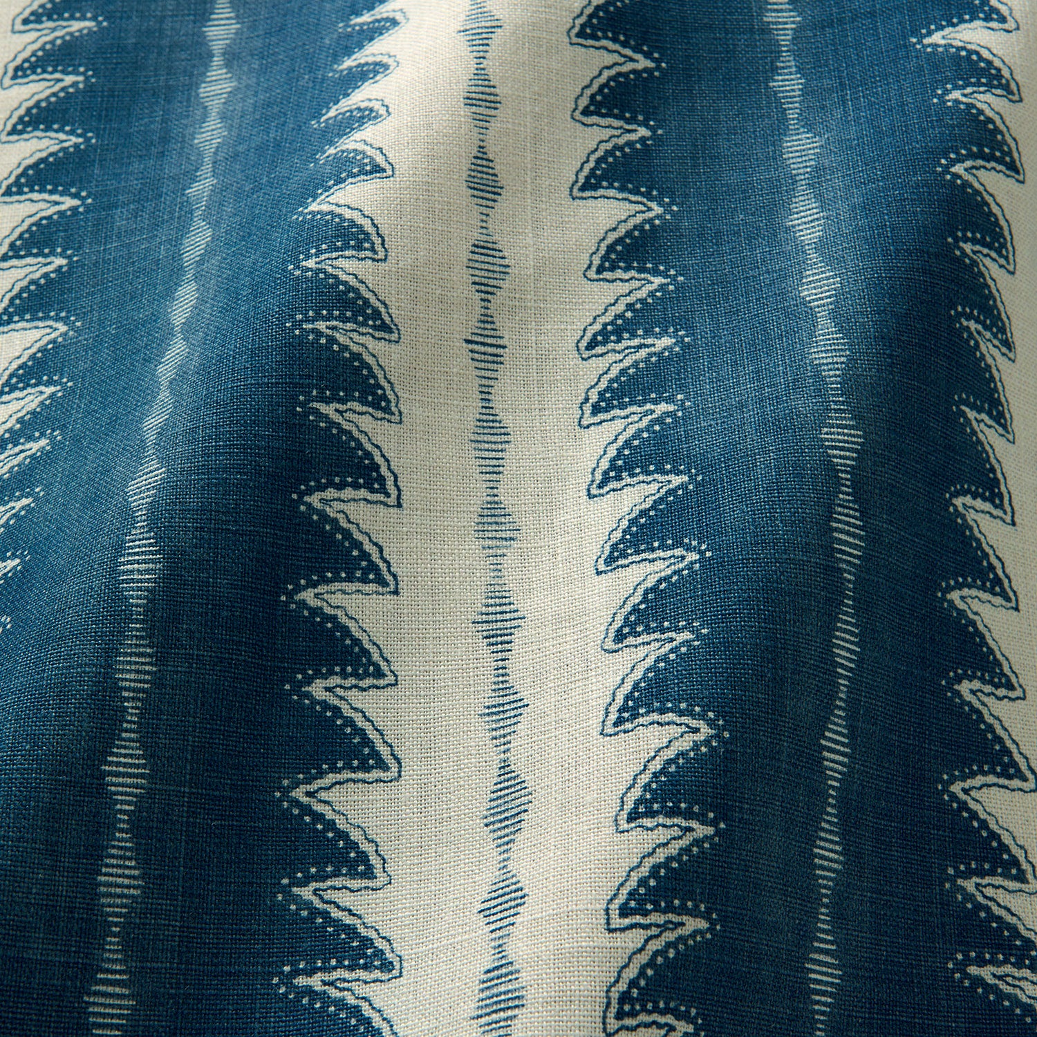 A printed linen fabric sample in blue and off white featuring a striped fern design.