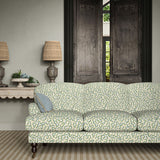 Sofa upholstered in a printed linen fabric in blue, green, and off white featuring a feel of a classic animal print.