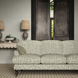 Sofa upholstered in a printed linen fabric in black, grey, and off white featuring a feel of a classic animal print.