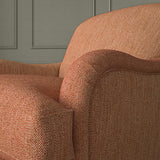Close-up of armchair in Loxley Punch by Linwood – durable, Italian-woven natural fibre fabric in bold coral pink.