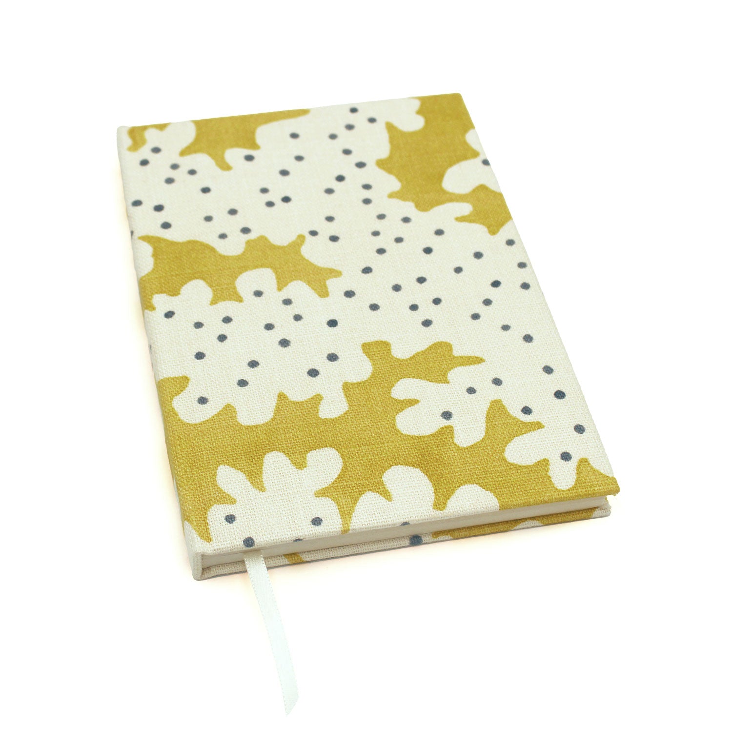 A yellow and cream linen notebook with a stylized coral pattern.