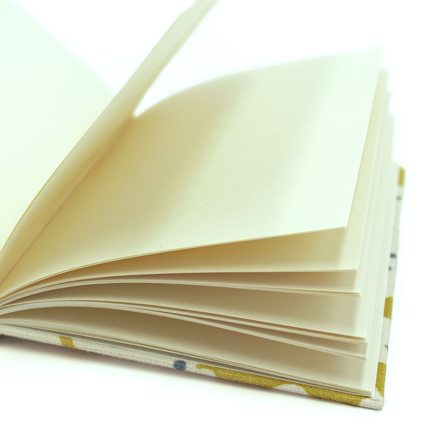 A yellow and cream linen notebook with a stylized coral pattern.
