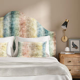 An upholstered headboard in a multicoloured printed velvet with pastel stripes.