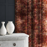 A curtain made from a printed velvet fabric in red and brown featuring a classic distressed pattern.