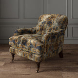 Armchair upholstered in a printed velvet fabric in blue, brown and black featuring an opulent pattern.