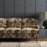 Sofa upholstered in a printed velvet fabric in blue, brown and black featuring an opulent pattern.