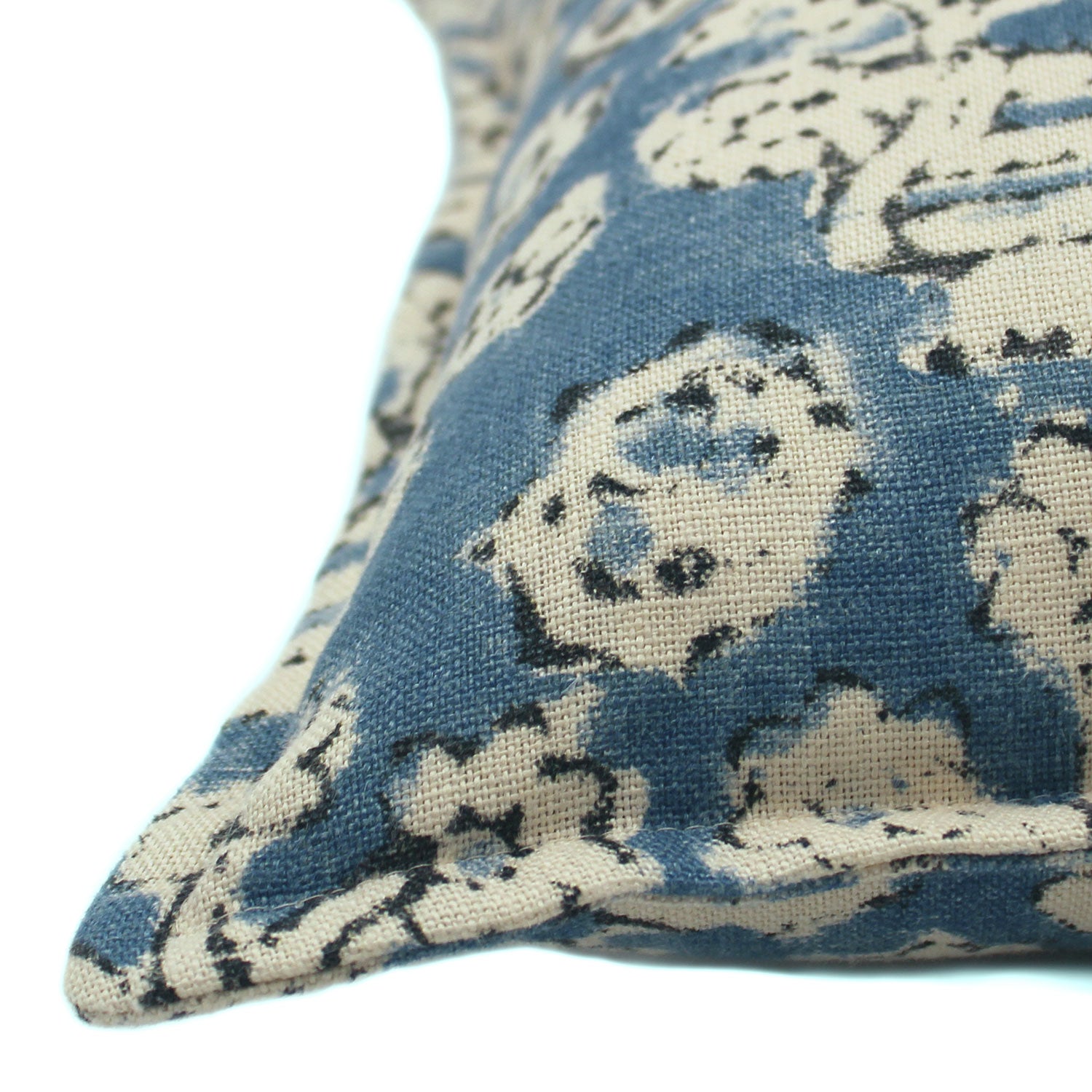 A blue, cream and black linen cushion with a block print pattern.