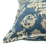 A blue, cream and black linen cushion with a block print pattern.