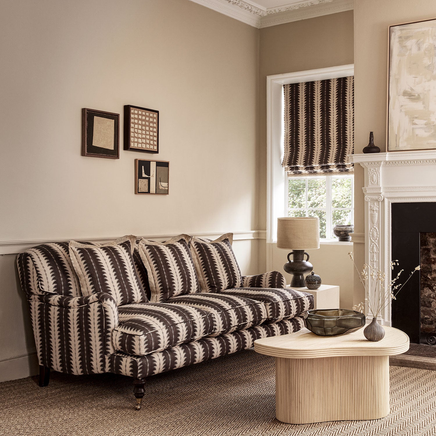 Sofa upholstered in a printed linen fabric in black and off white, featuring a striped fern design.