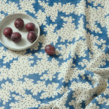 A printed linen fabric sample in blue, black and off white featuring a stylized coral pattern.