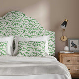 Headboard upholstered in a printed linen fabric sample in green, black and off white featuring a stylized coral pattern.