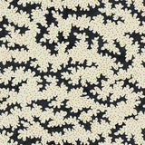 A printed linen fabric sample in black, brown and off white featuring a stylized coral pattern.