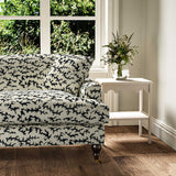 Sofa upholstered in a printed linen fabric sample in black, brown and off white featuring a stylized coral pattern.