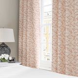 Curtains made from a printed linen fabric sample in pink, red and off white featuring a stylized coral pattern.