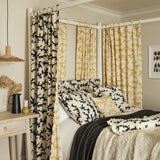 Sofa upholstered in a printed linen fabric sample in black, brown and off white featuring a stylized coral pattern.