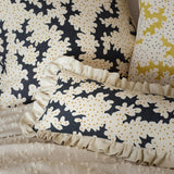 Cushions made from a printed linen fabric sample in black, brown and off white featuring a stylized coral pattern.