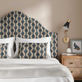 Headboard upholstered in a printed linen fabric sample in blue, orange and off white featuring a stylized fern pattern.