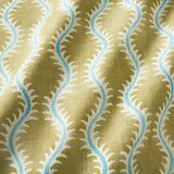 A printed linen fabric sample in yellow, blue and off white featuring a stylized fern pattern.