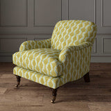Chair upholstered in a printed linen fabric sample in yellow, blue and off white featuring a stylized fern pattern.