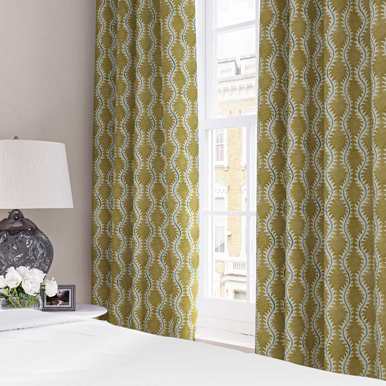 Curtains made from a printed linen fabric sample in yellow, blue and off white featuring a stylized fern pattern.