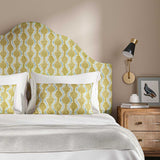 Headboard upholstered in a printed linen fabric sample in yellow, blue and off white featuring a stylized fern pattern.