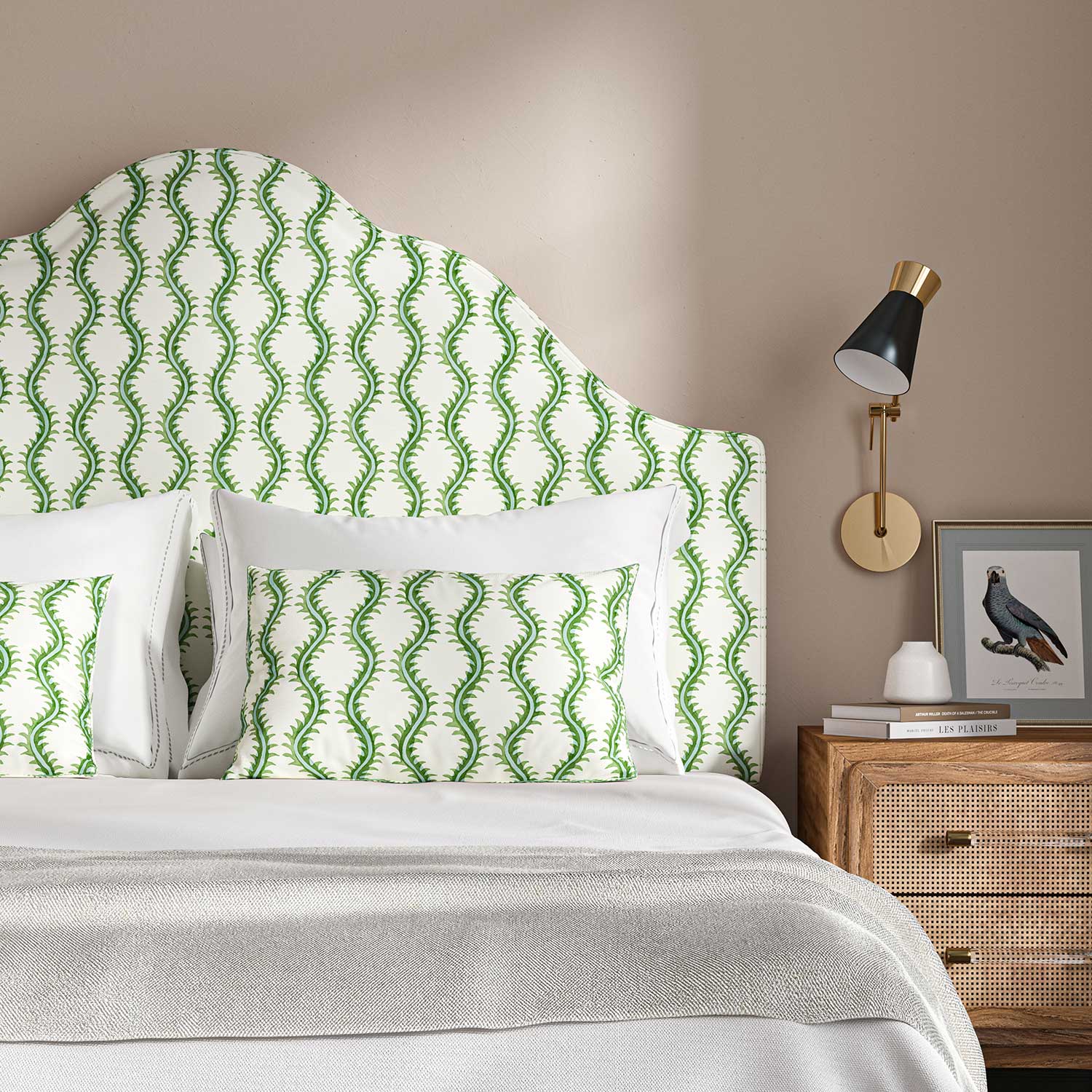 Headboard upholstered in a printed linen fabric sample in blue and off white featuring a stylized fern pattern.