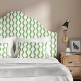 Headboard upholstered in a printed linen fabric sample in blue and off white featuring a stylized fern pattern.