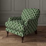 Chair upholstered in a printed linen fabric sample in green and off white featuring a stylized fern pattern.
