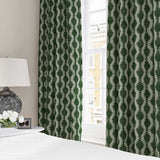 Curtains made from a printed linen fabric sample in green and off white featuring a stylized fern pattern.