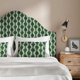 Headboard upholstered in a printed linen fabric sample in green and off white featuring a stylized fern pattern.