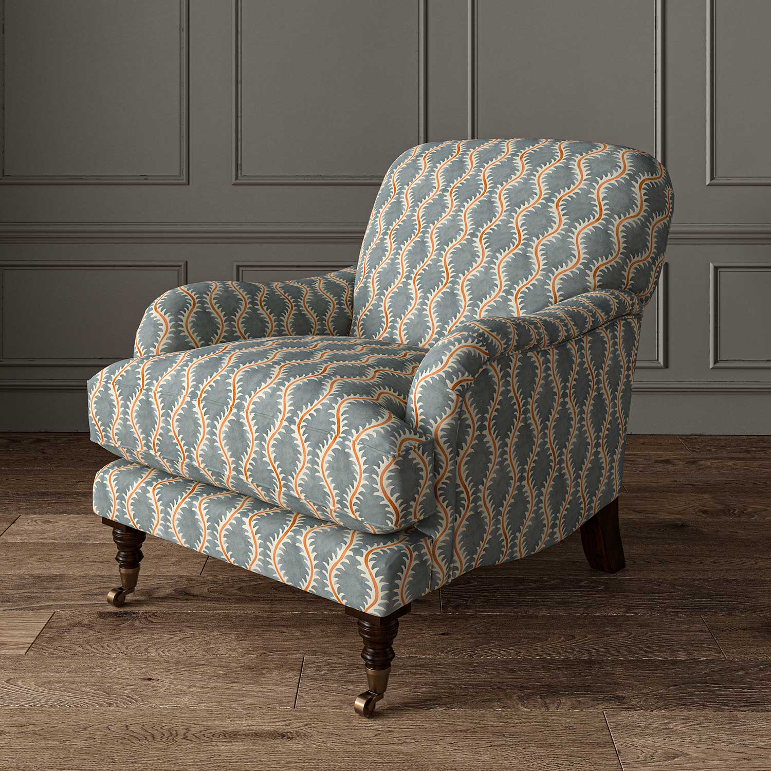 Chair upholstered in a printed linen fabric sample in blue, orange and off white featuring a stylized fern pattern.