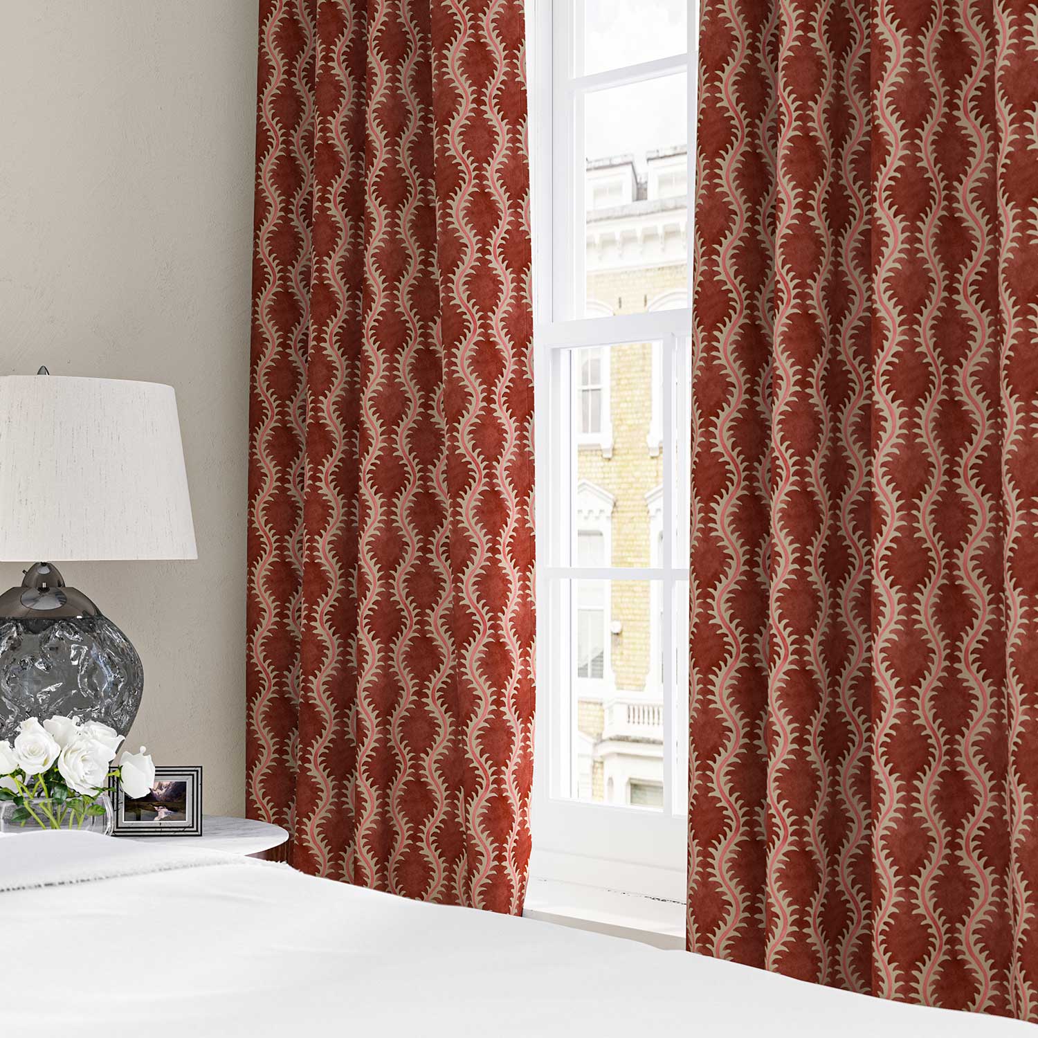 Curtains made from a printed linen fabric sample in red and pink featuring a stylized fern pattern.