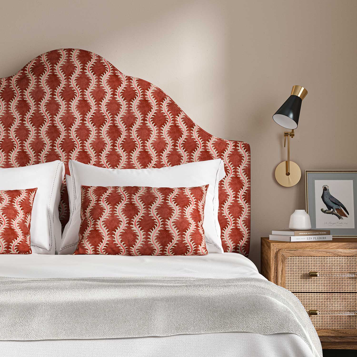 Headboard upholstered in a printed linen red and pink featuring a stylized fern pattern.